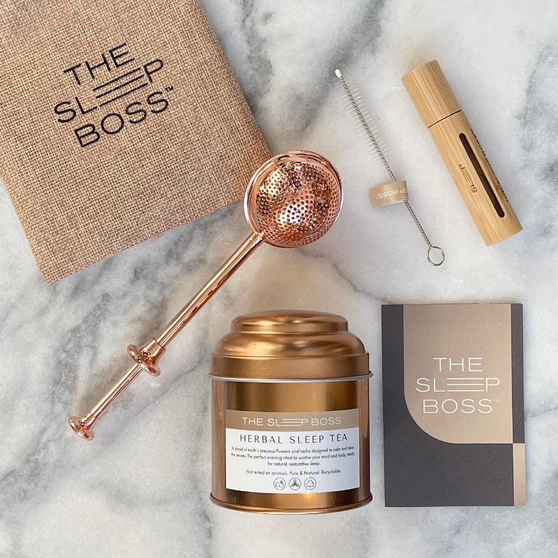 Herbal Sleep Tea and Essential Oil Roller in a kit on a marble table