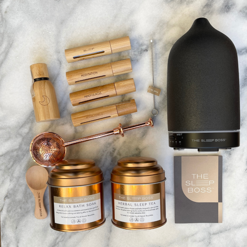 A colleciton of herbal sleep tea, relaxing magnesium bath soak, black essential oil diffuser and essential oil roller set and a pure essential oil blend