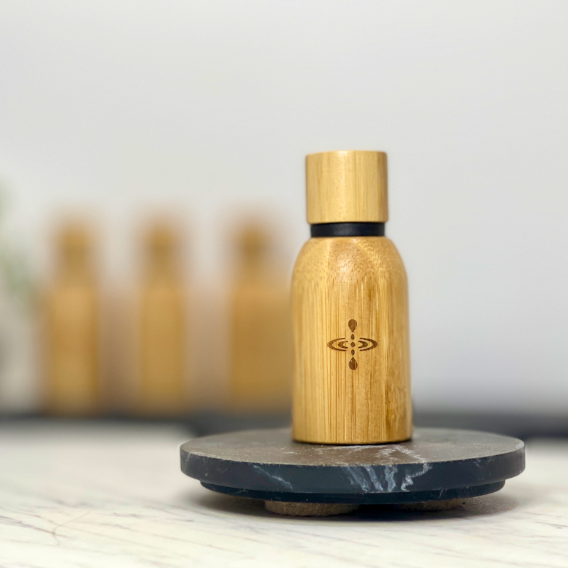 15ml of Sleep Blend Pure Essential Oil encased in bamboo held up to show the elegant bamboo casing