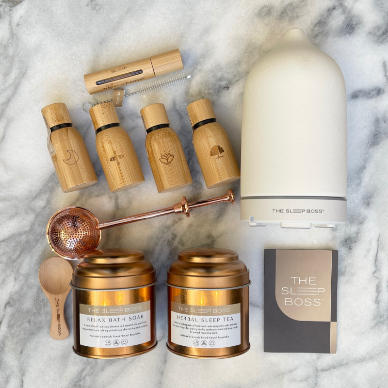 Slumber Gift Set with Herbal sleep tea, relaxing bath soak, 4 signature essential oil blends and an essential oil roller on a marble base