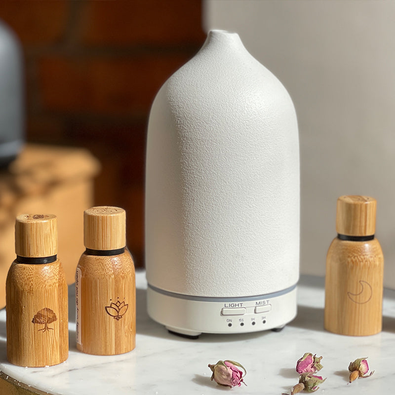 a white ceramic diffuser with meditation oil in bamboo casing