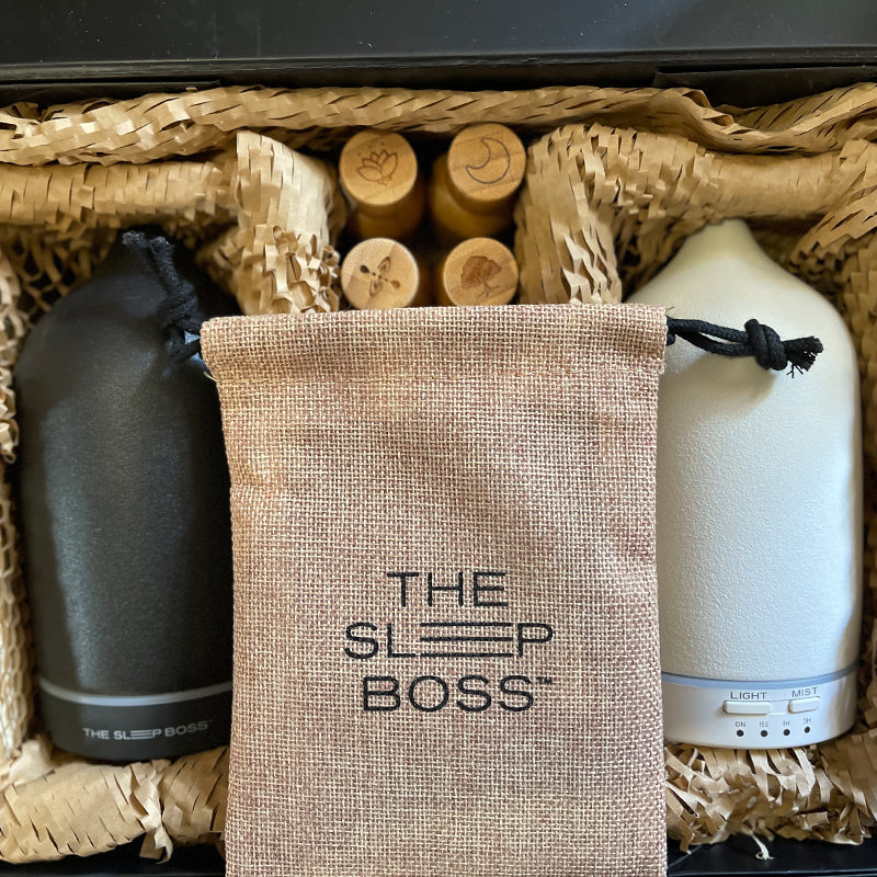a black and a white ceramic diffusers, oil blends in bamboo casing and a pouch inside a gift box