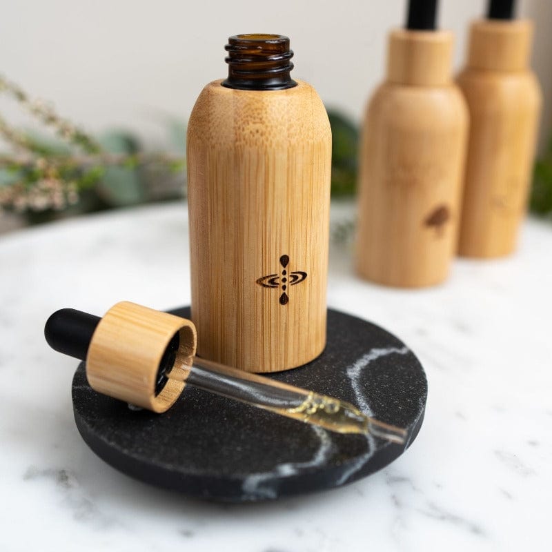 a bottle of Mindfulness Luxury Oil on top of black marble plate