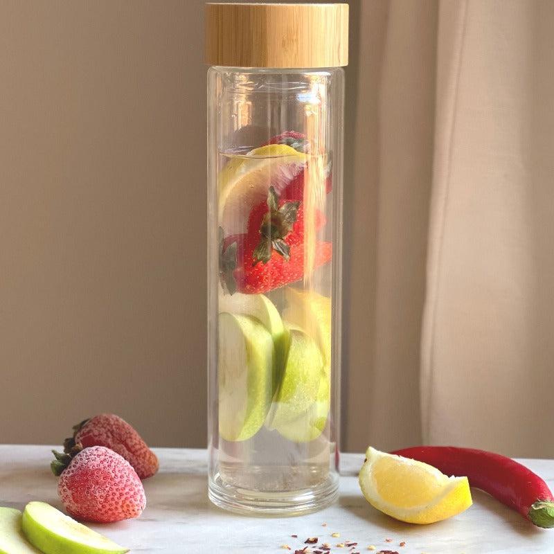 glass bottle with water and fruits inside it